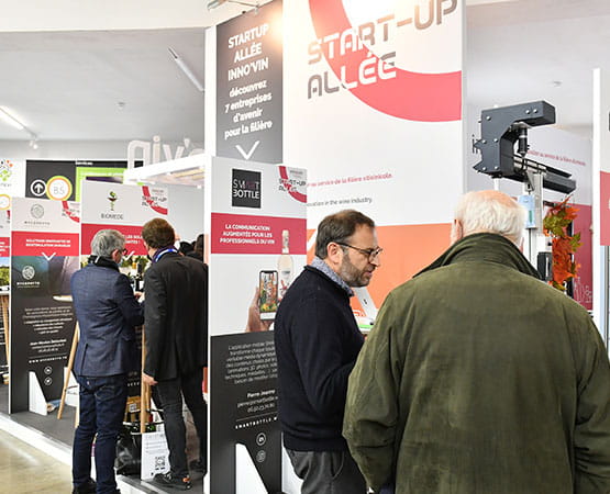 People chatting at a business meeting in front of a start-up's stand
